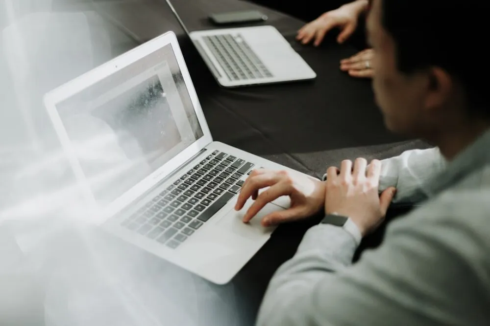 Content marketer ที่ใช้ AI workflow ทำงานกับ laptop หลายหน้าจอ แสดงให้เห็นถึงประสิทธิภาพที่เพิ่มขึ้นในการผลิต content