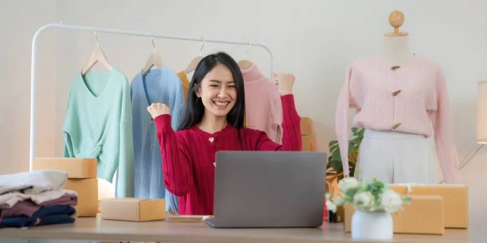 เจ้าของธุรกิจ SME ชาวเอเชียกำลังจัดการร้านออนไลน์บน laptop พร้อมเริ่มต้นใช้ AI ช่วยในธุรกิจ