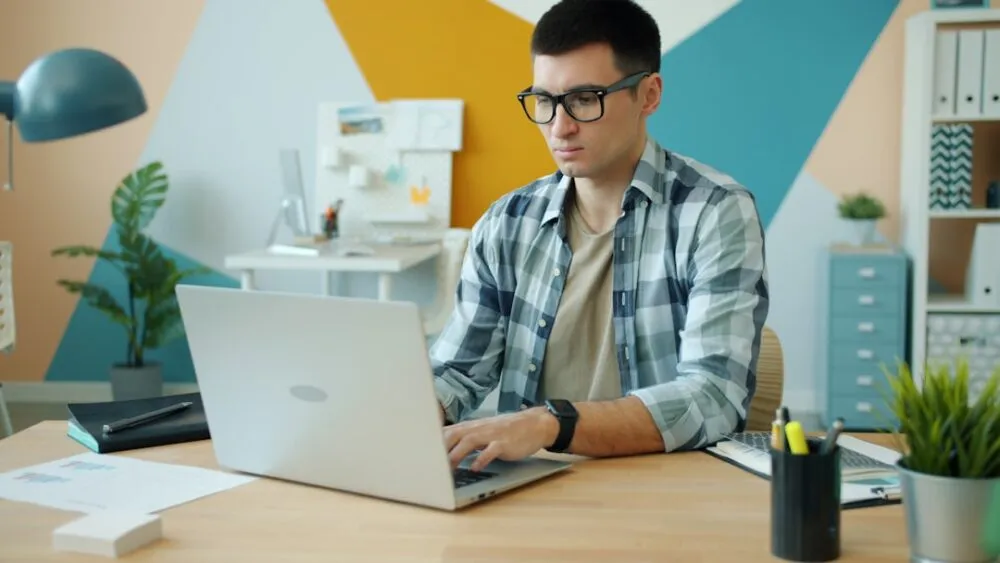 ฟรีแลนซ์ทำเงินด้วย AI กำลังสร้างระบบ automation workflow บนแล็ปท็อปในห้องทำงานที่บ้าน เพื่อรับงาน Automation Freelance